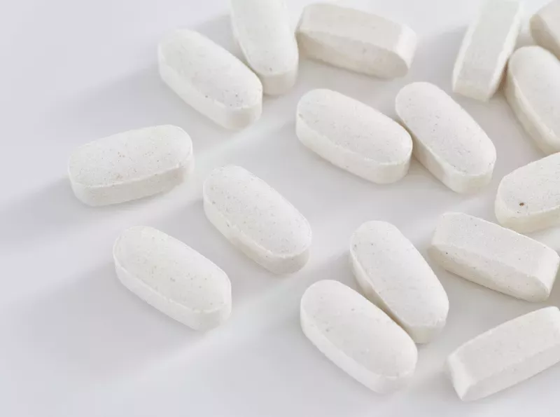 White tablets against a white background.