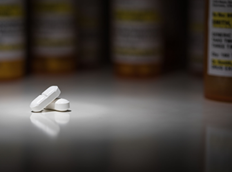 Hydrocodone Pills and Prescription Bottles Under Spot Light.