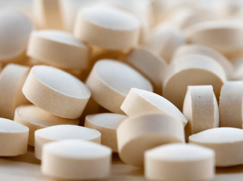 A close up shot of white round tablets.