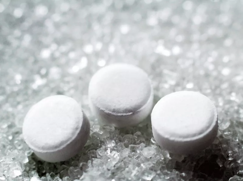 Sugar tablets resting on clear sugar granules.